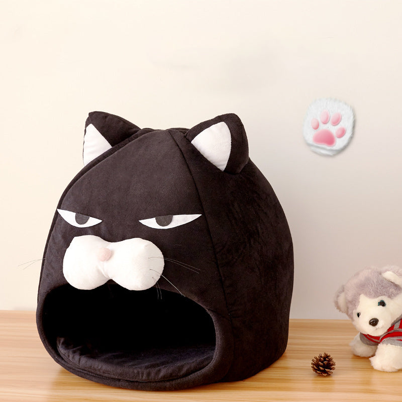 Black cat-shaped pet bed on a wooden surface with a light background