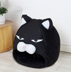 Black cat-shaped pet bed on a light wooden floor with a white wall background